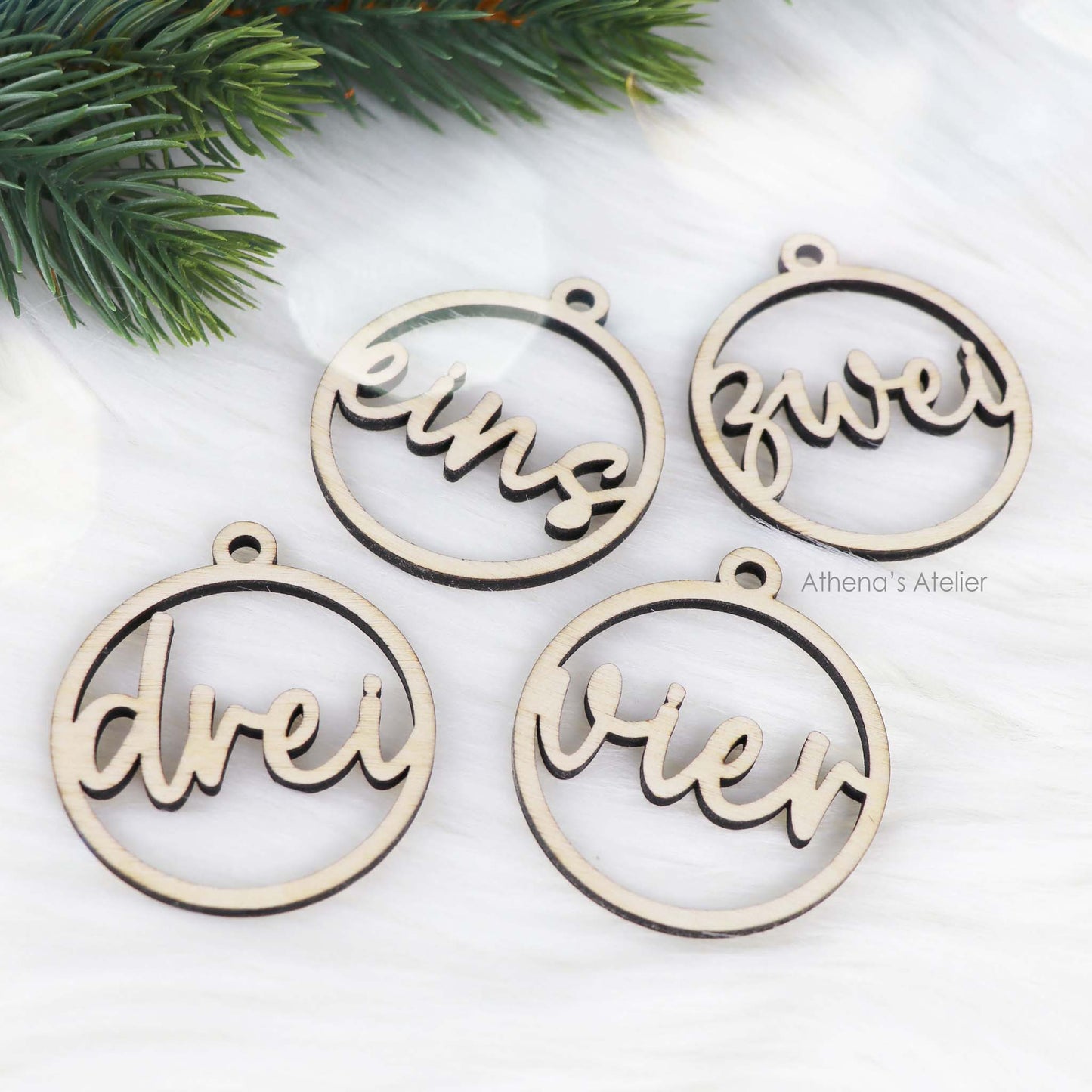Set aus vier runden Adventszahlen aus hellem Holz, mit den Wörtern eins, zwei, drei, vier in eleganter Schreibschrift lasergeschnitten.