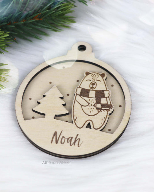 Runder Weihnachtsbaum-Anhänger aus Holz, personalisiert mit einem Bärchen und Wunschnamen.
