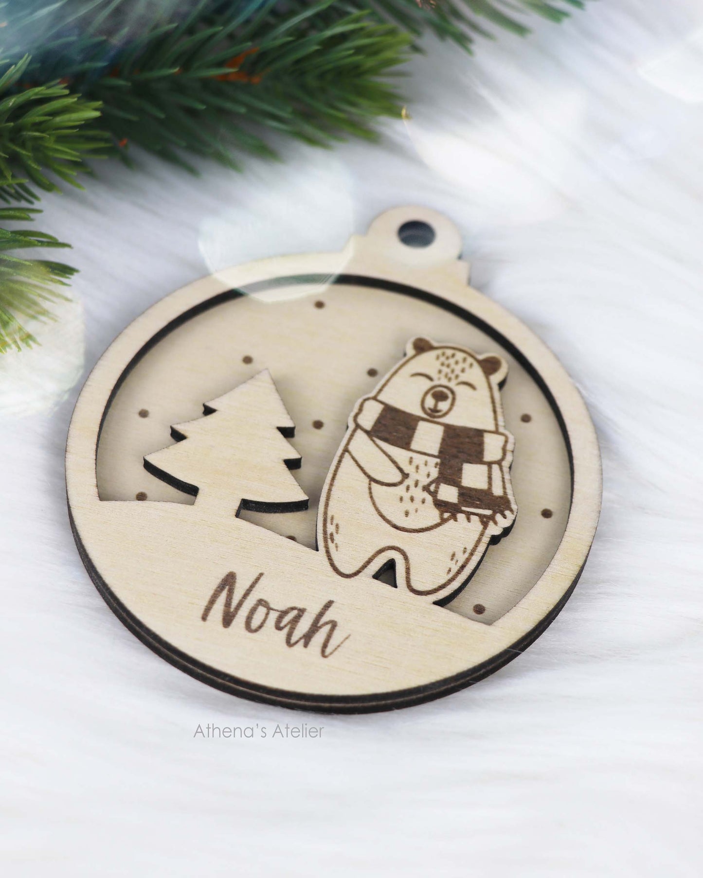 Runder Weihnachtsbaum-Anhänger aus Holz, personalisiert mit einem Bärchen und Wunschnamen.