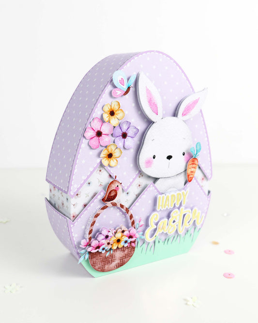 Handgefertigte Oster-Geschenkbox in Eiform aus hochwertigem Motivkarton mit Hasen-Motiv und Aufschrift Frohe Ostern – Athena's Atelier.