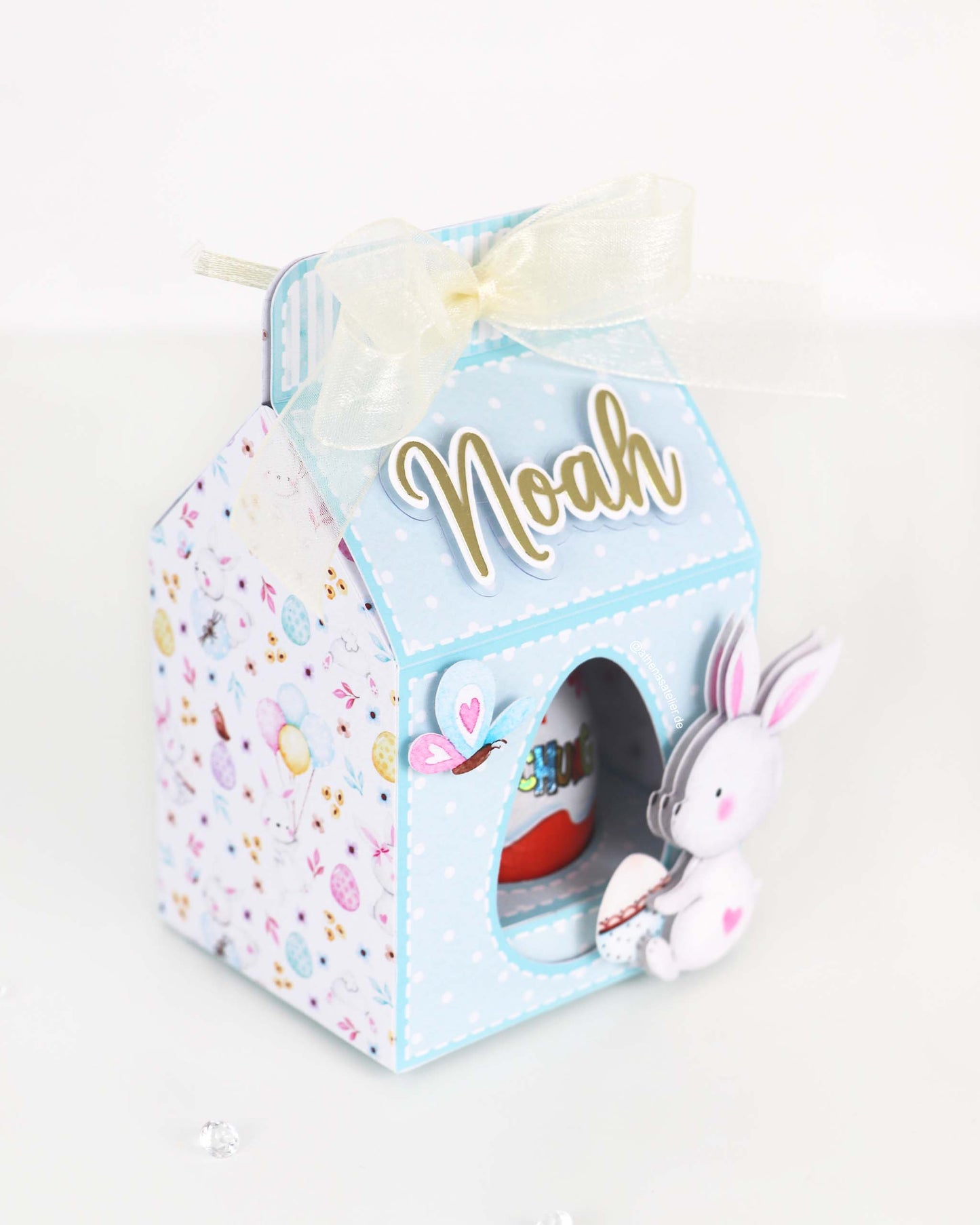 Personalisierte Oster-Geschenkbox aus Motivkarton für Schokoeier, handgefertigt mit Wunschnamen – Athena's Atelier.