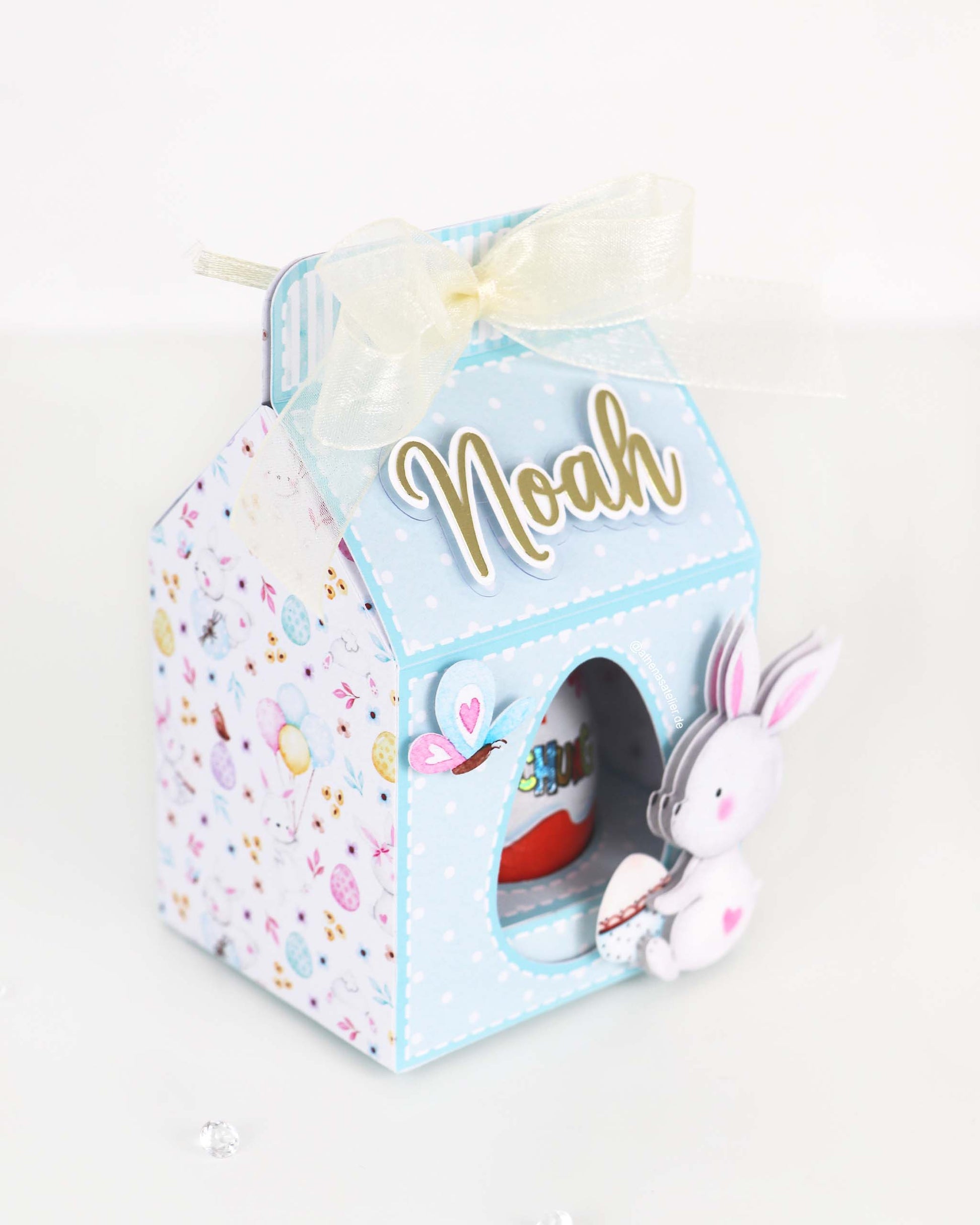 Personalisierte Oster-Geschenkbox aus Motivkarton für Schokoeier, handgefertigt mit Wunschnamen – Athena's Atelier.