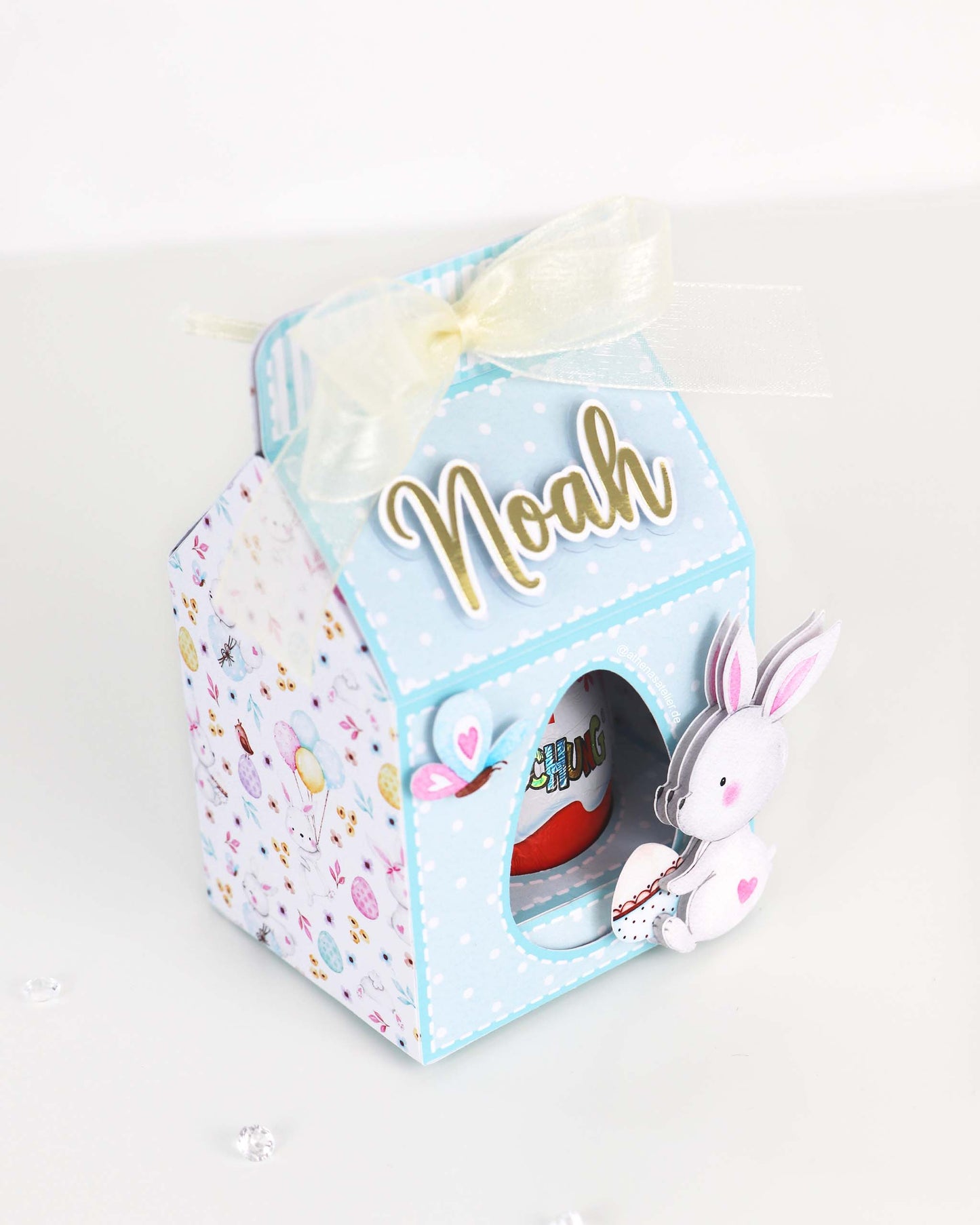 Personalisierte Oster-Geschenkbox aus Motivkarton für Schokoeier, handgefertigt mit Wunschnamen – Athena's Atelier.