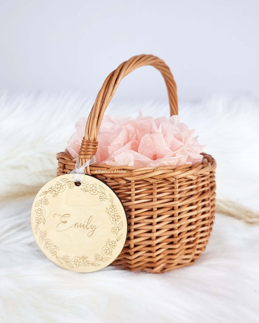 Personalisierter Holzanhänger mit Blumenkranz-Gravur und Wunschnamen an einem kleinen Osterkörbchen – Athena's Atelier.