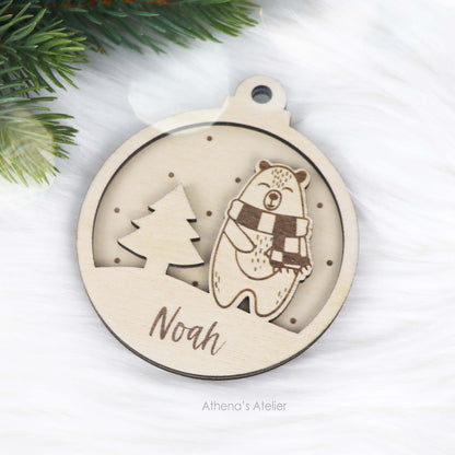 Runder Weihnachtsbaum-Anhänger aus Holz, personalisiert mit einem Bärchen und Wunschnamen.