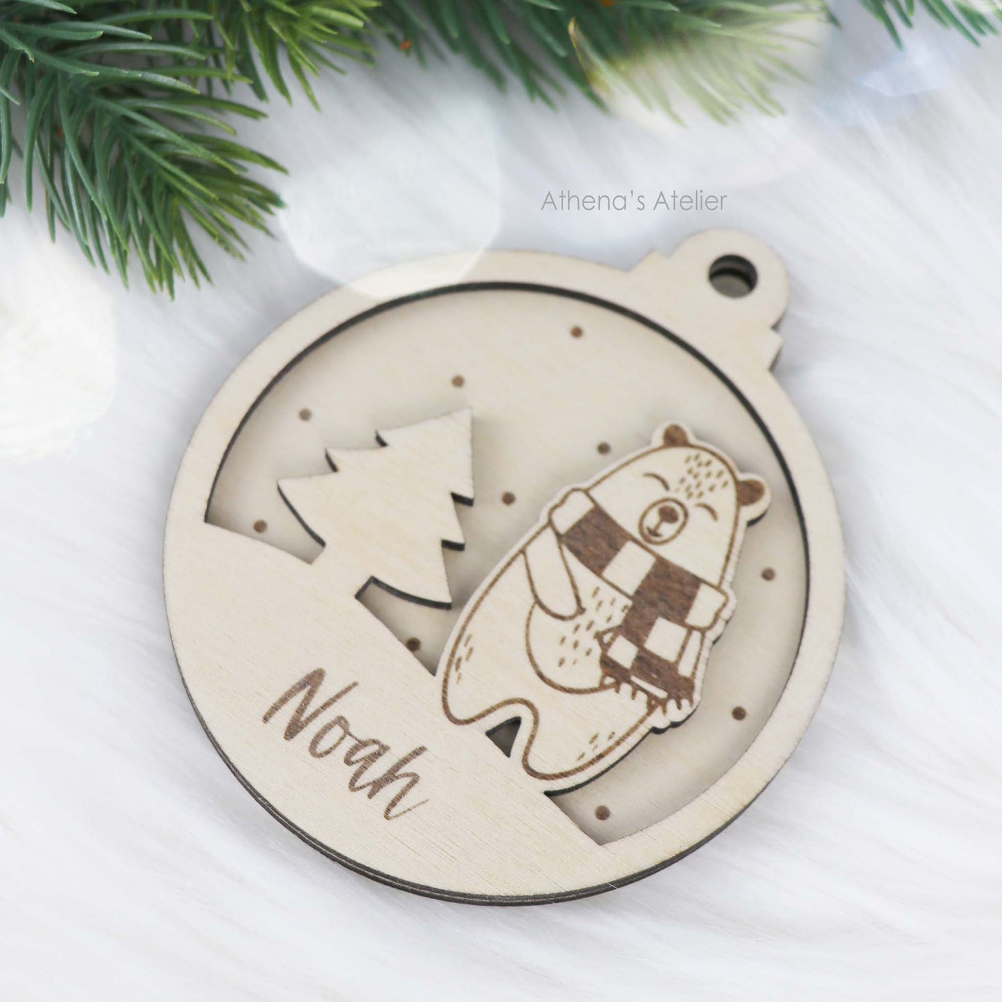 Runder Weihnachtsbaum-Anhänger aus Holz, personalisiert mit einem Bärchen und Wunschnamen.
