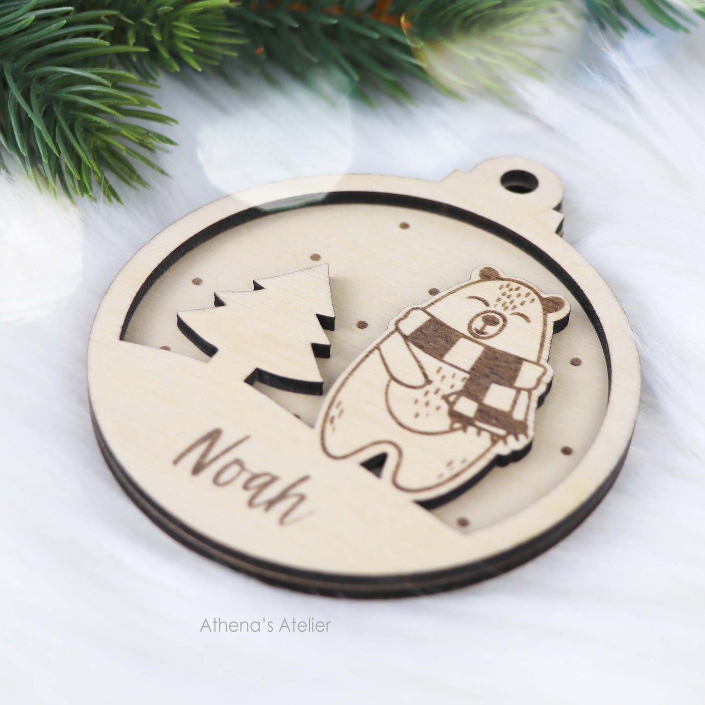 Runder Weihnachtsbaum-Anhänger aus Holz, personalisiert mit einem Bärchen und Wunschnamen.