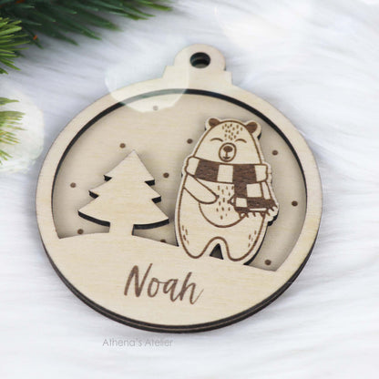 Runder Weihnachtsbaum-Anhänger aus Holz, personalisiert mit einem Bärchen und Wunschnamen.