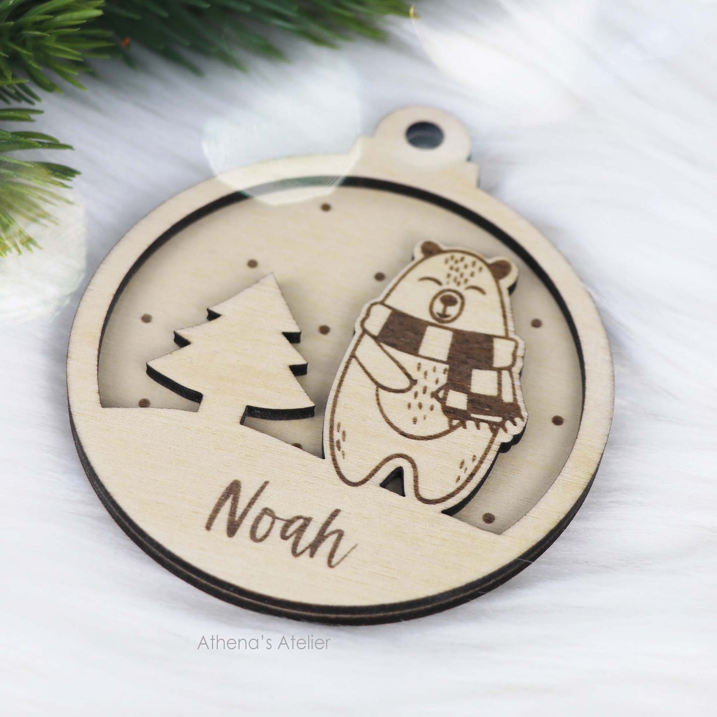 Runder Weihnachtsbaum-Anhänger aus Holz, personalisiert mit einem Bärchen und Wunschnamen.