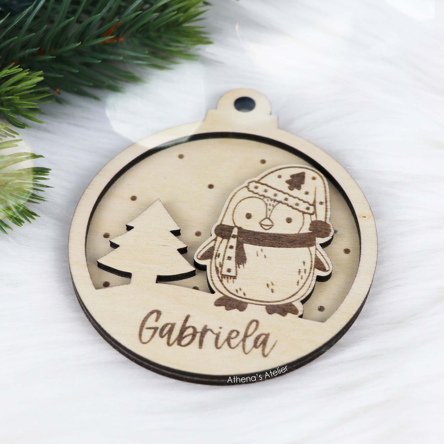 Runder Weihnachtsbaum-Anhänger aus Holz, personalisiert mit einem Pinguin und Wunschnamen.