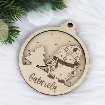 Runder Weihnachtsbaum-Anhänger aus Holz, personalisiert mit einem Pinguin und Wunschnamen.