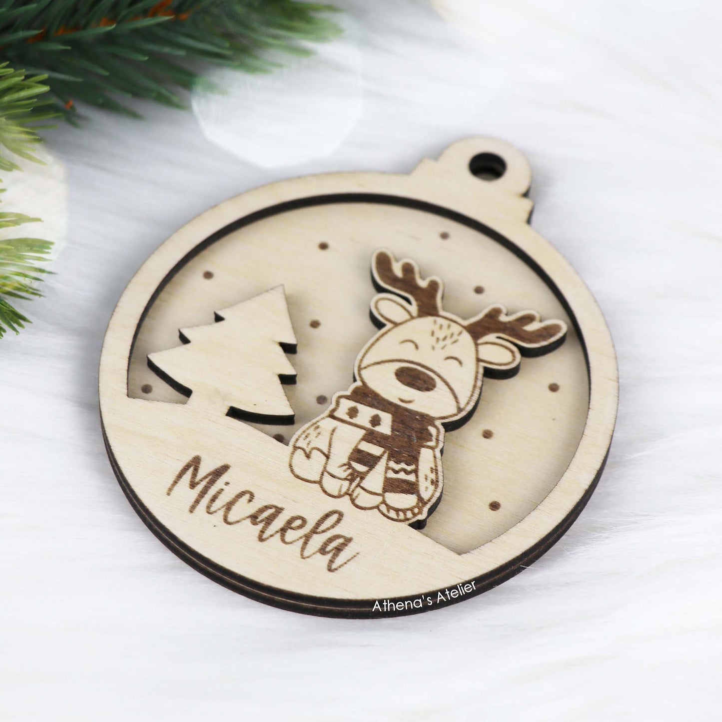Runder Weihnachtsbaum-Anhänger aus Holz, personalisiert mit einem Rentier und Wunschnamen.