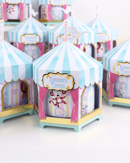 Personalized circus tent carousel spinning centerpiece in light blue and pink with hand-drawn animal illustrations by Athenas Atelier.